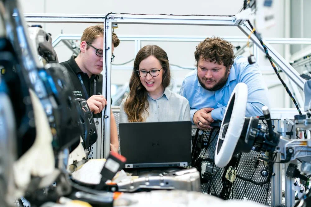 Intelligente Services Technologie - a group of people looking at a laptop